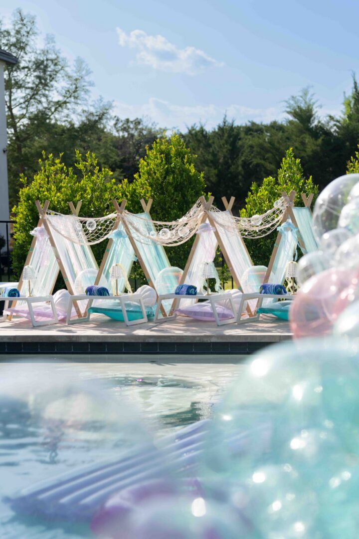Poolside tents with colorful balloons.