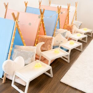 Colorful indoor tents with pillows and lights.