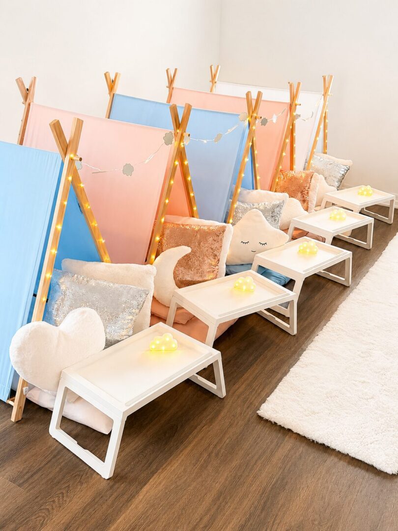 Colorful indoor tents with pillows and lights.