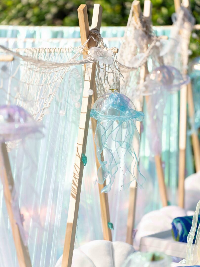 Decorative jellyfish hang on wooden frames.