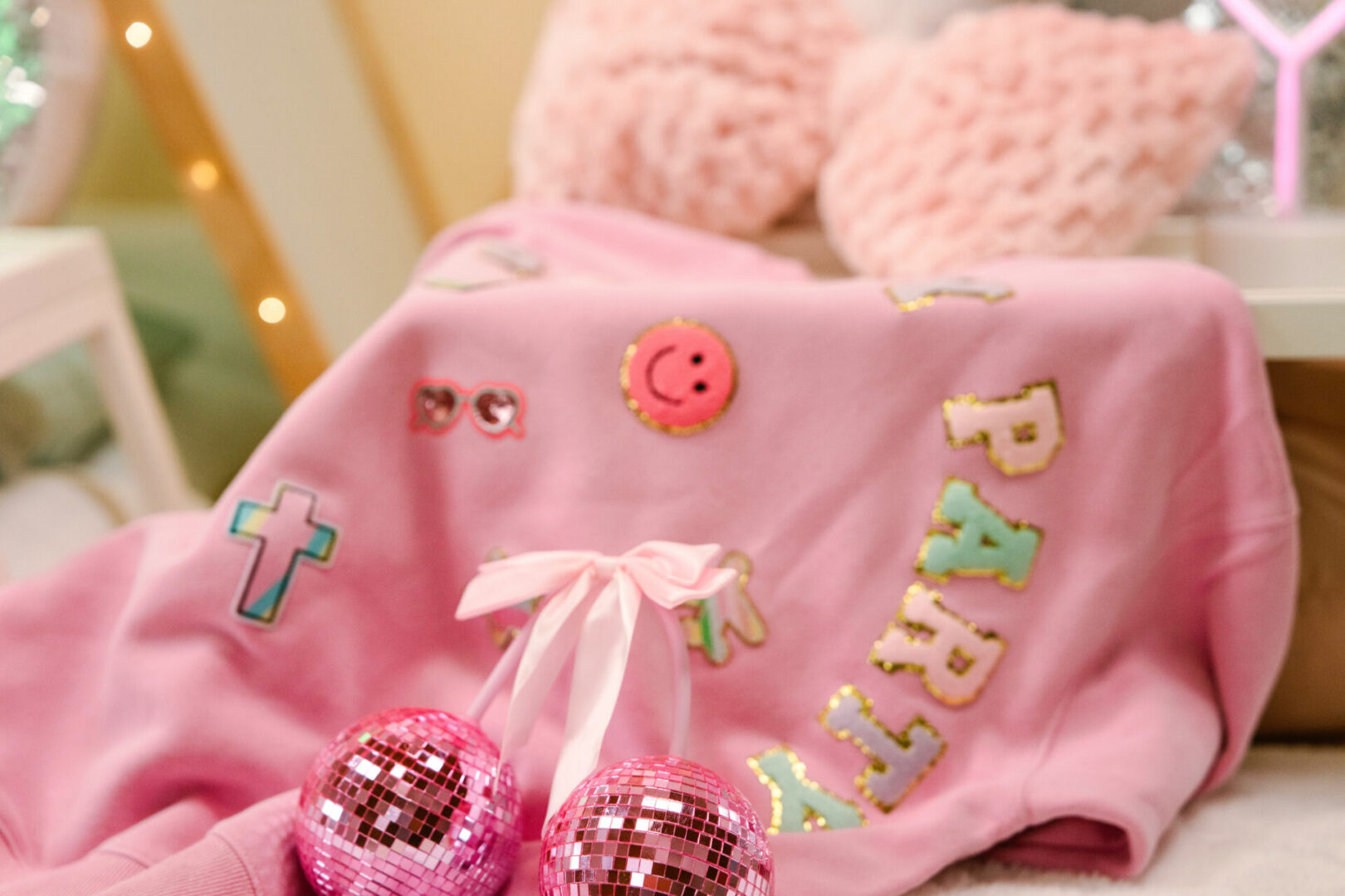 Pink sweater with decorations and glitter balls.