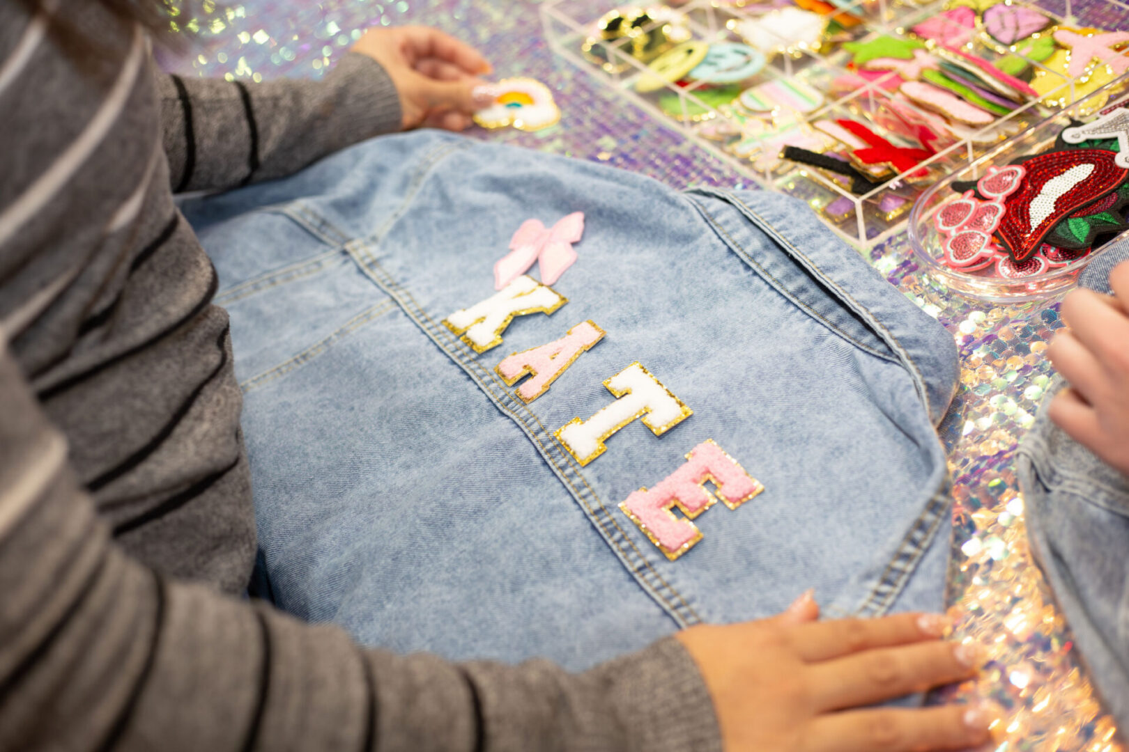 Denim jacket with colorful name patches.
