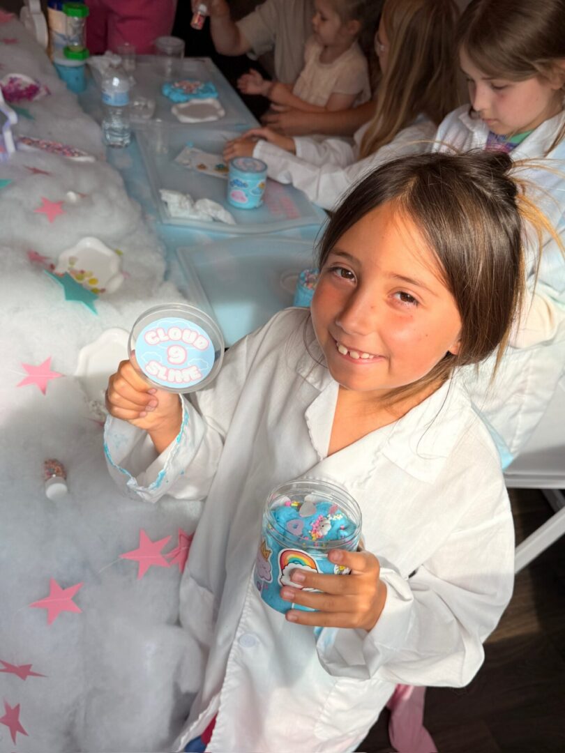 Child holding candy at a party table.
