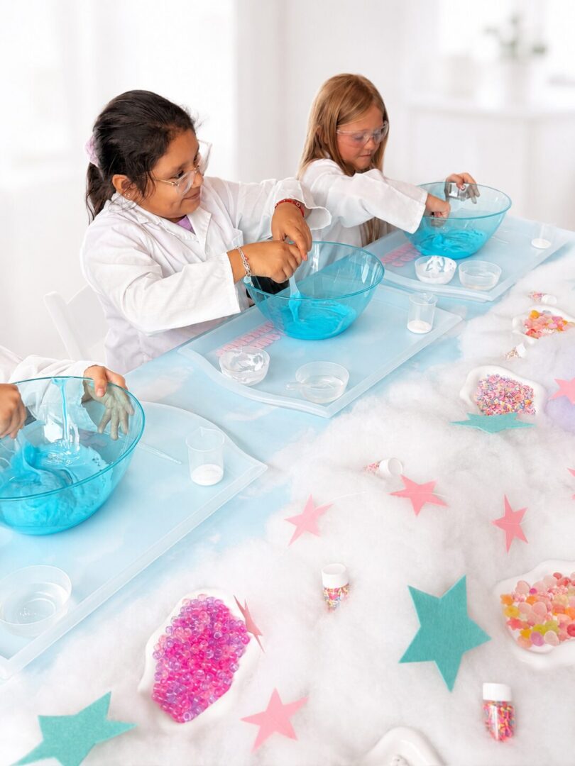 Children mixing blue liquid in bowls.