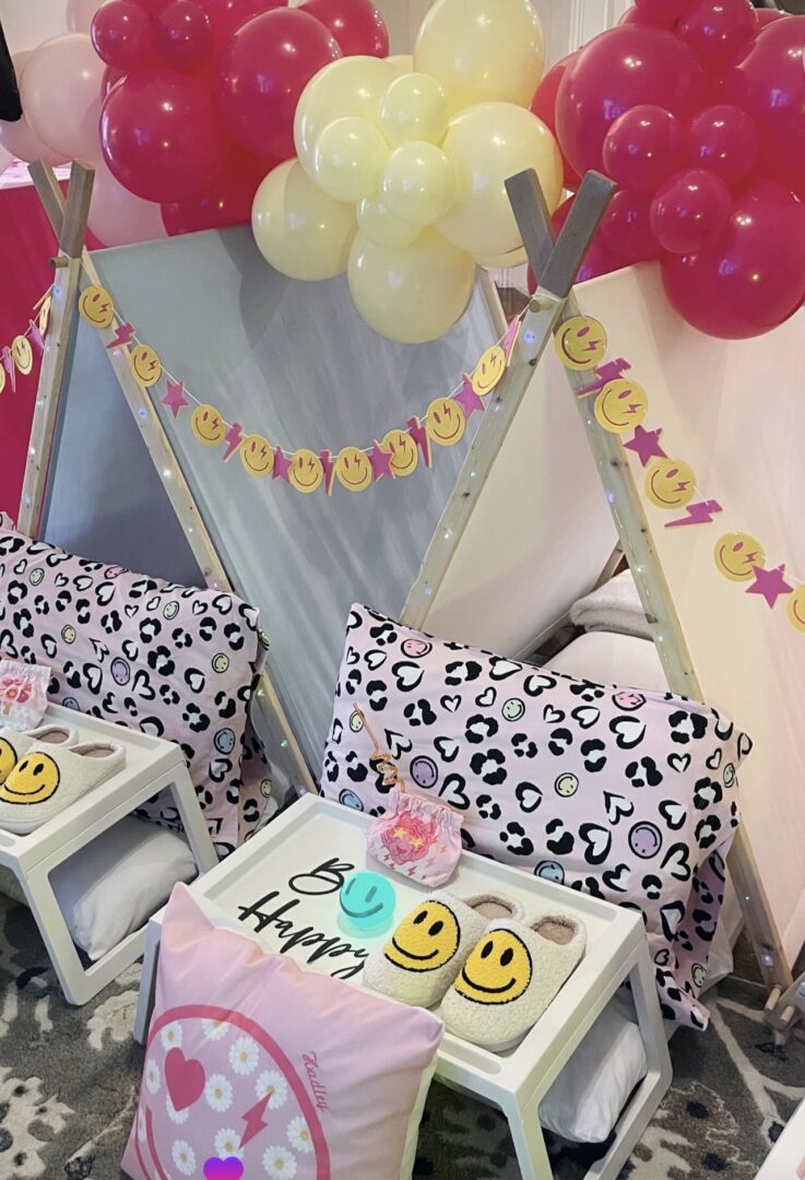 Sleepover setup with balloons and smiley faces.