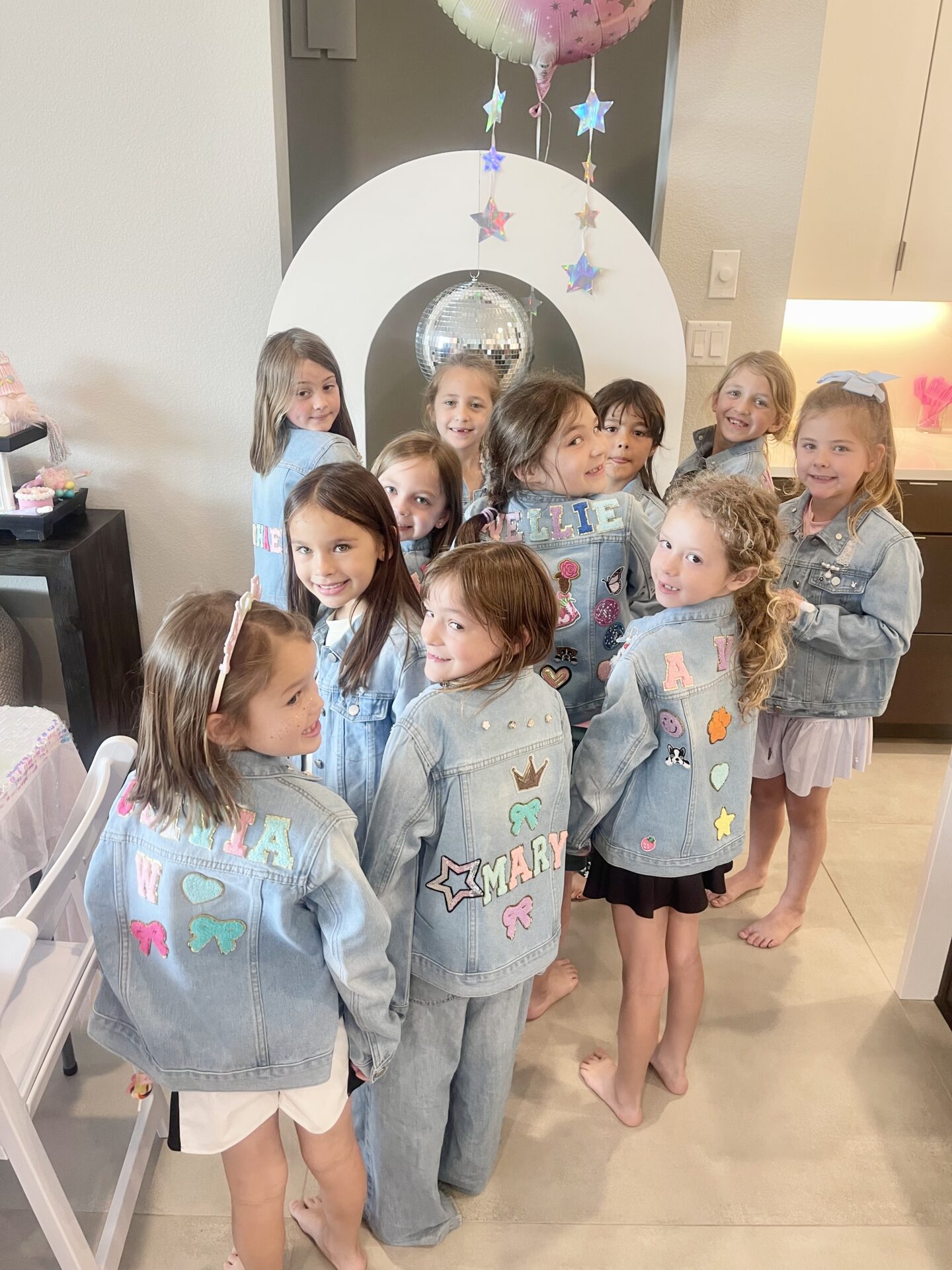Group of girls standing in front of a mirror, wearing denim jackets