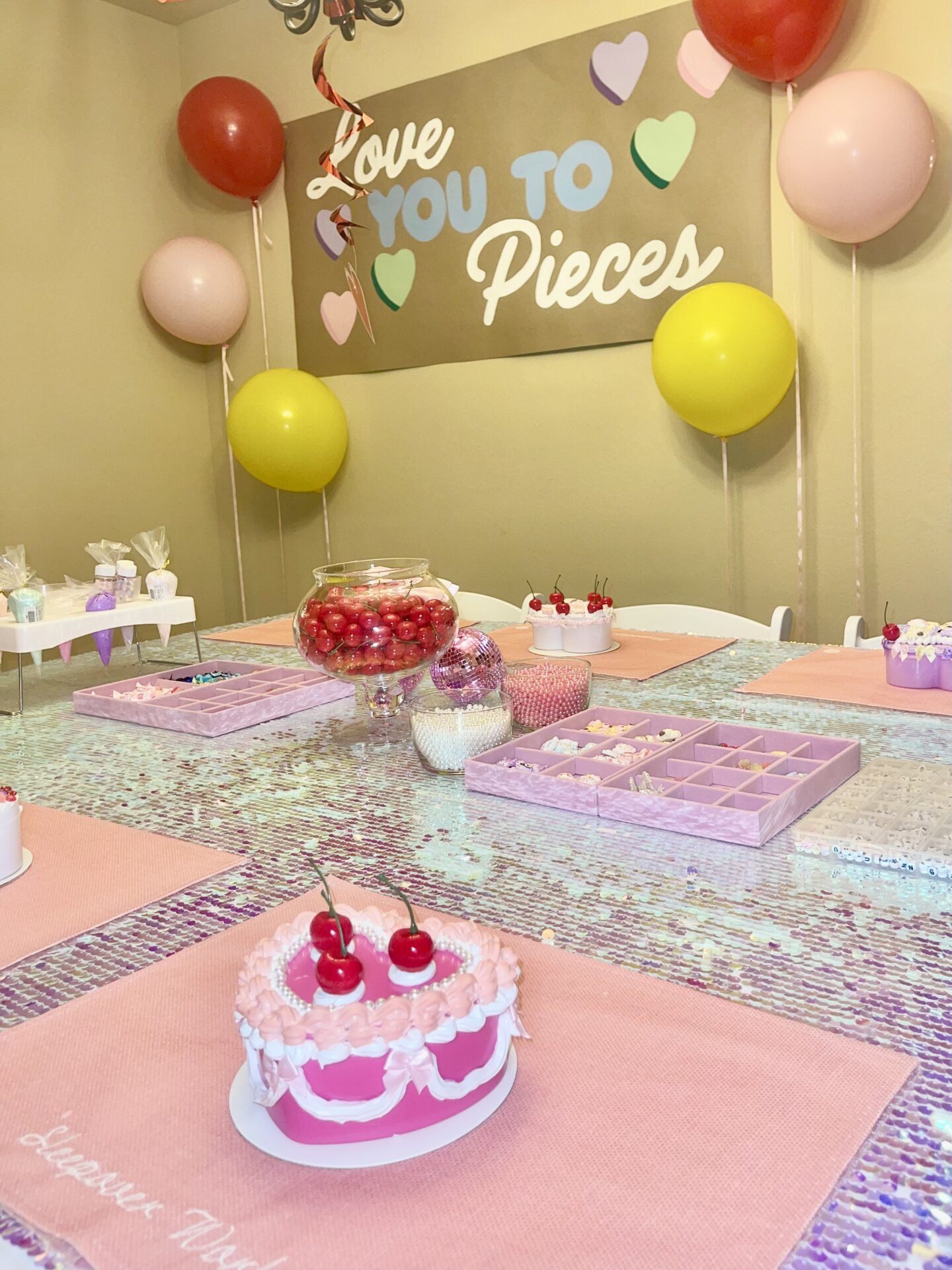 Table with a pink and white cake on top of it