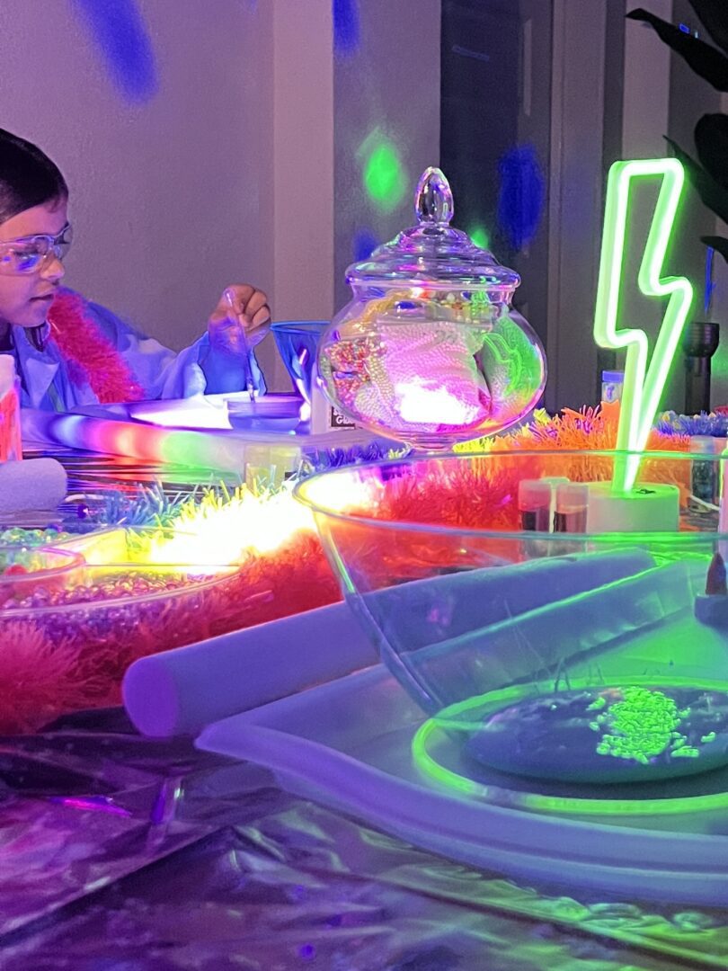 Child experimenting with neon-lit science equipment.