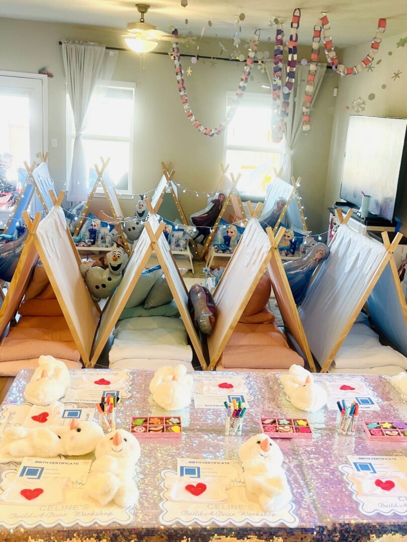 Indoor children's party with tents and decorations.