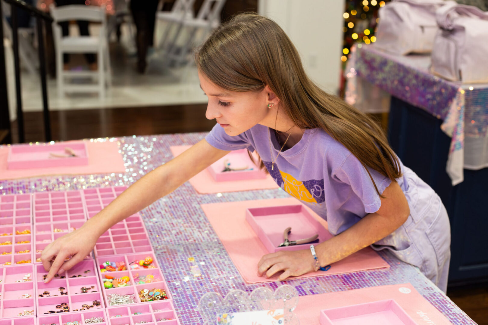 Girl selecting beads at a crafting table.