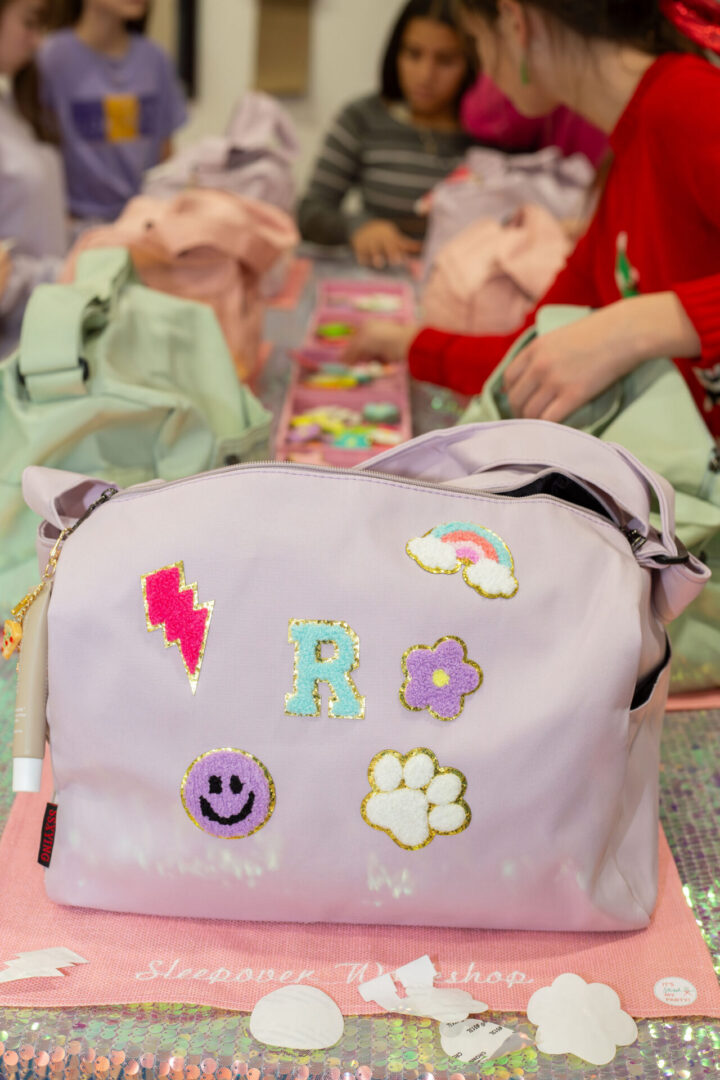 Decorated purple bag on craft table.