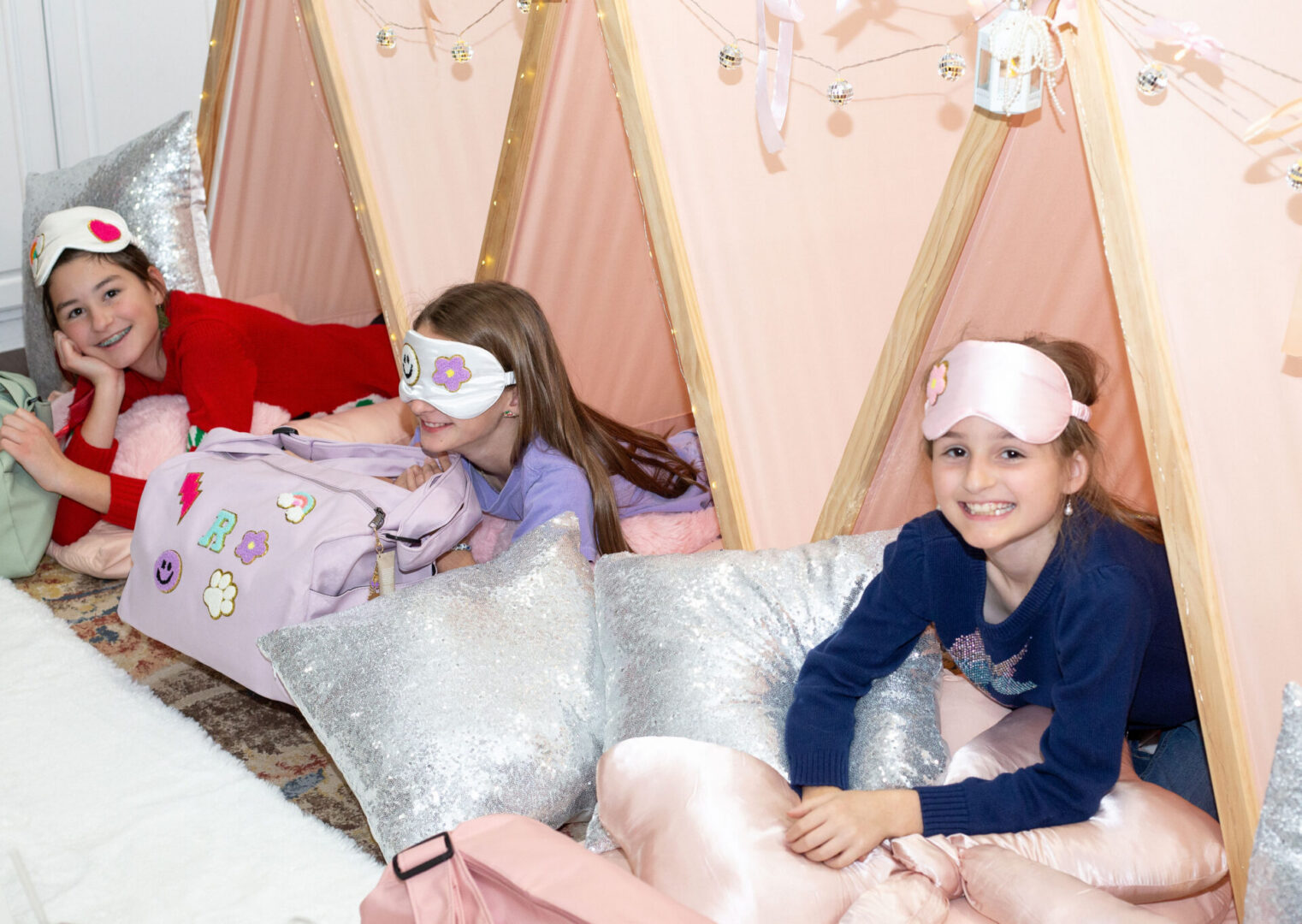 Children enjoying a sleepover in pink tents.