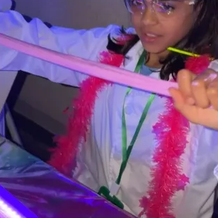 Child in lab coat playing with slime.