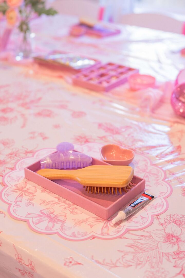 Pink table with hairbrushes and accessories.