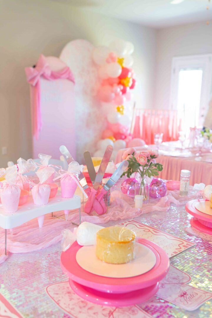 Pink-themed party table with decorations.