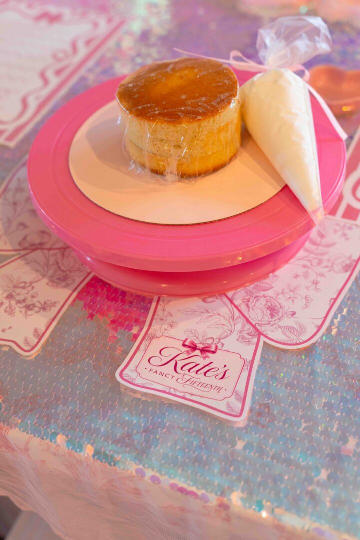 Cheesecake with icing bag on pink plate.