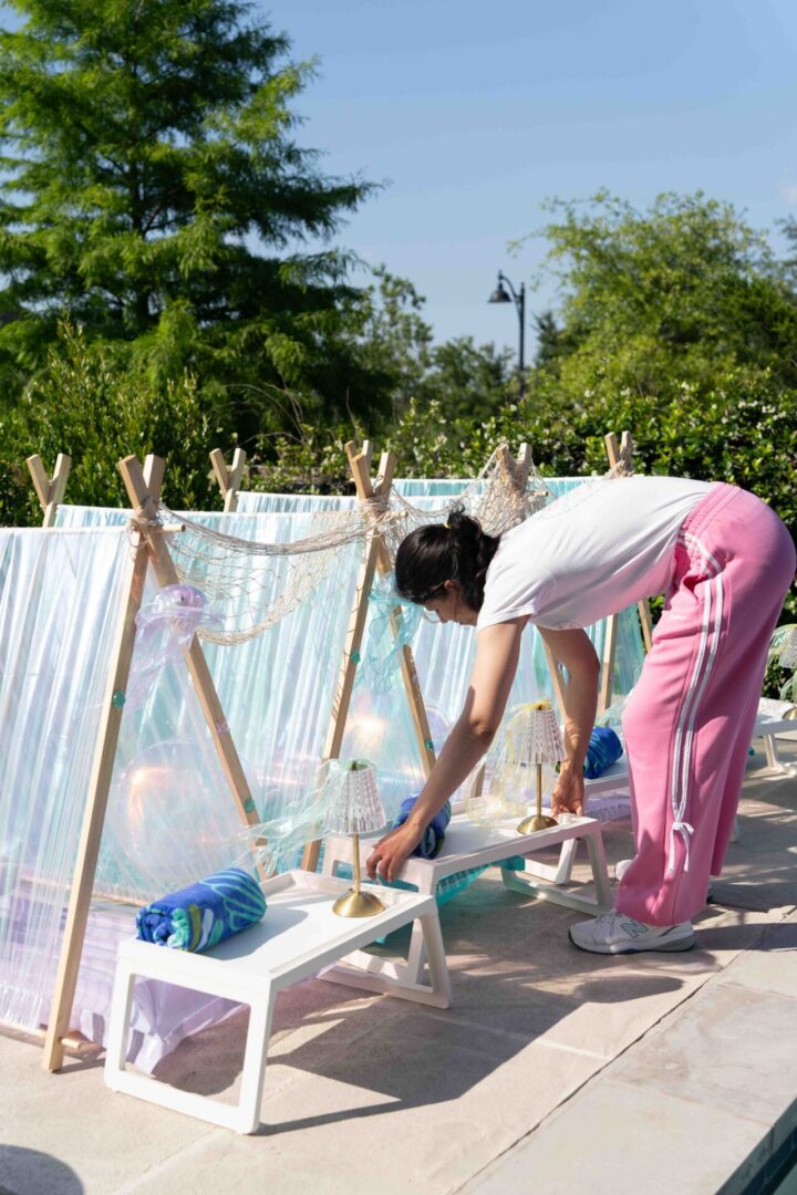Person setting up outdoor tent decorations.