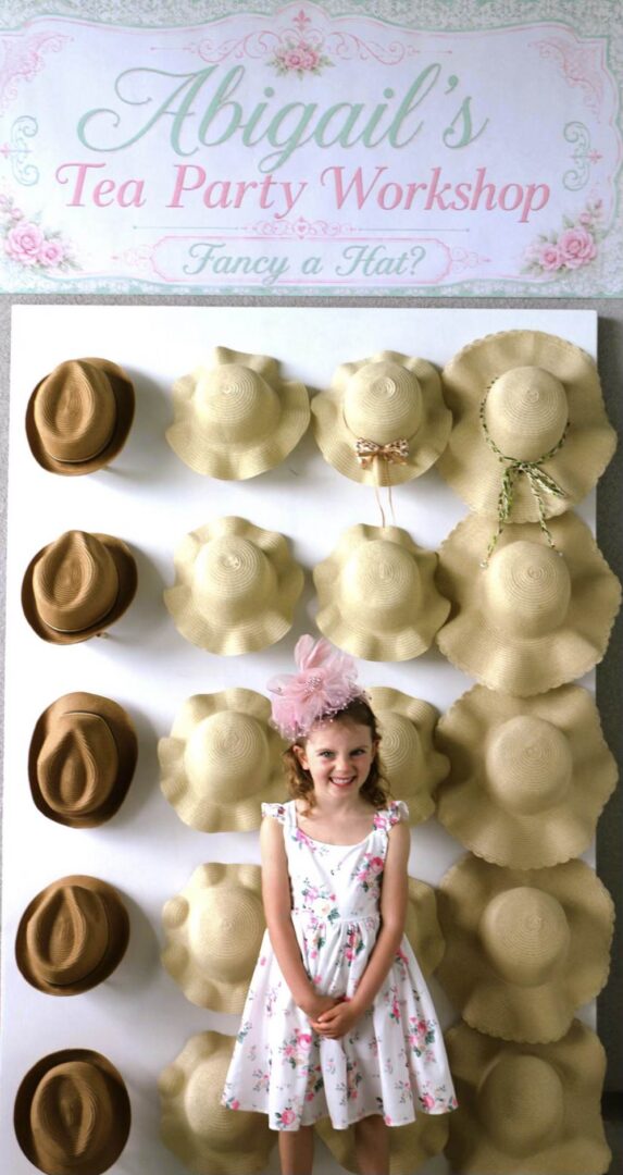 Girl at tea party hat workshop display.