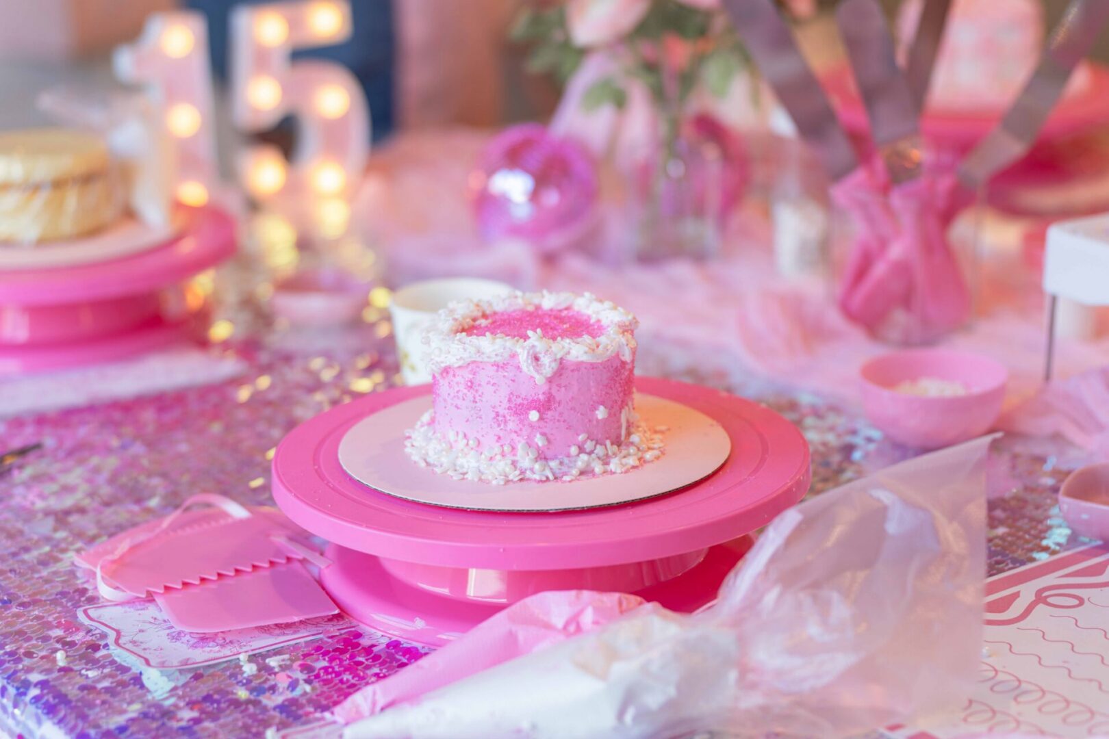 Pink birthday cake with decorative sprinkles.