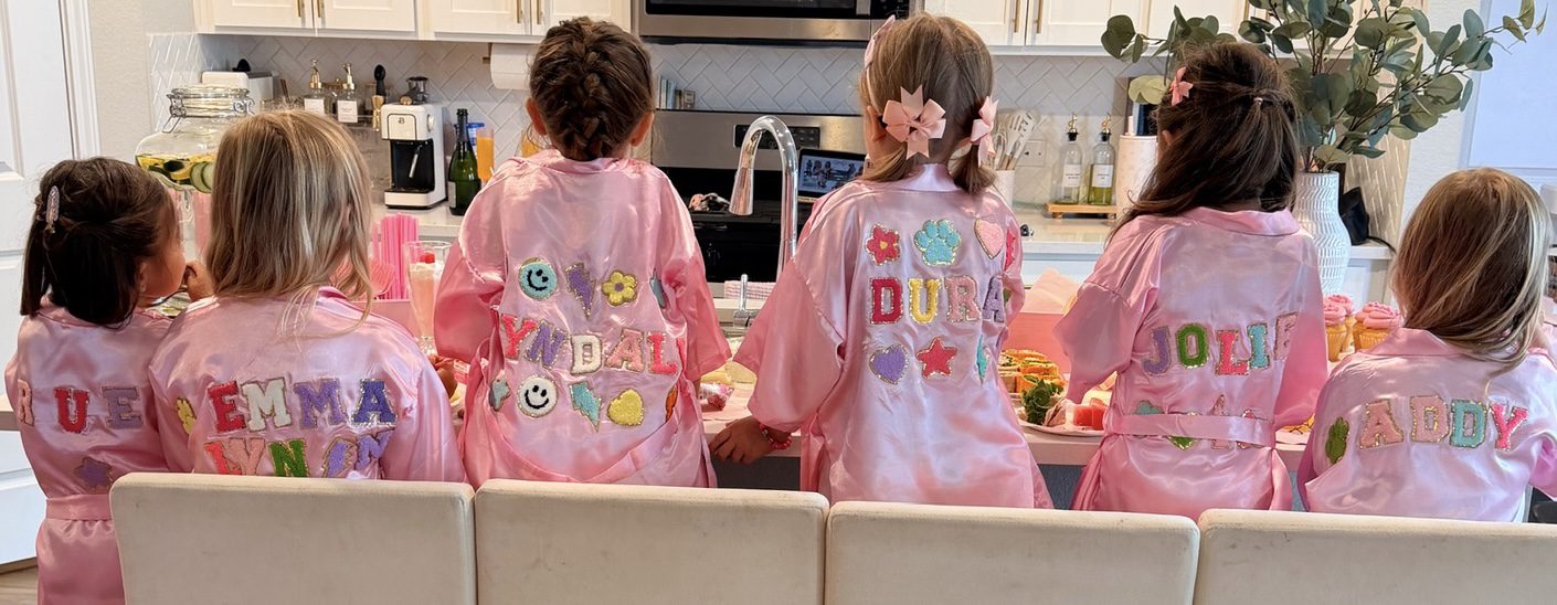 Children in pink robes sitting together.