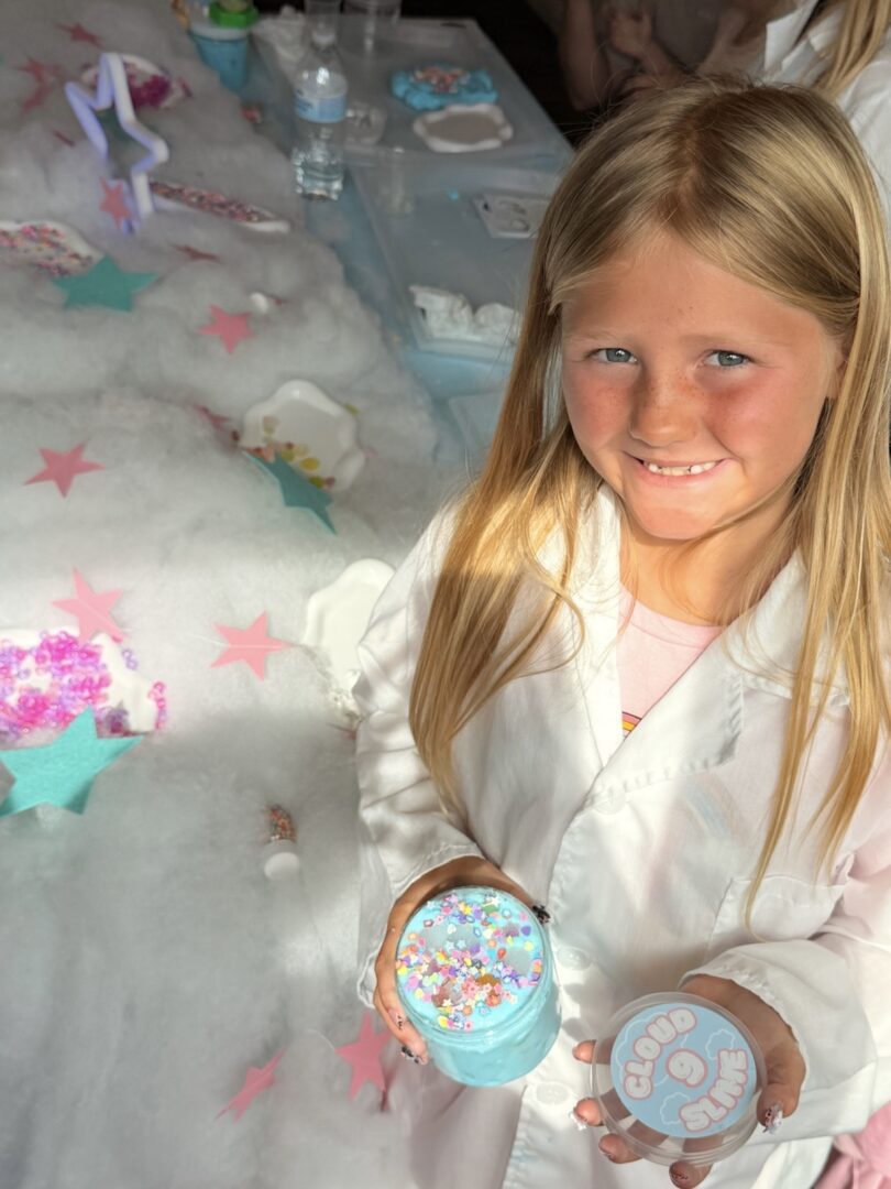 Girl holding colorful slime at party.