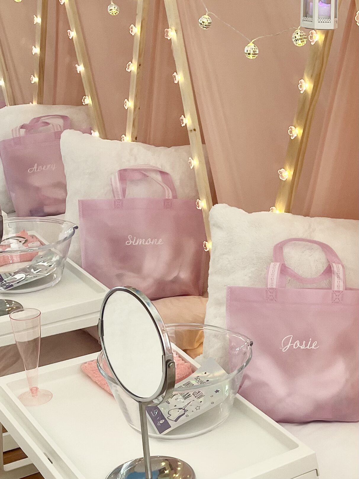 Pink-themed spa setup with personalized bags.