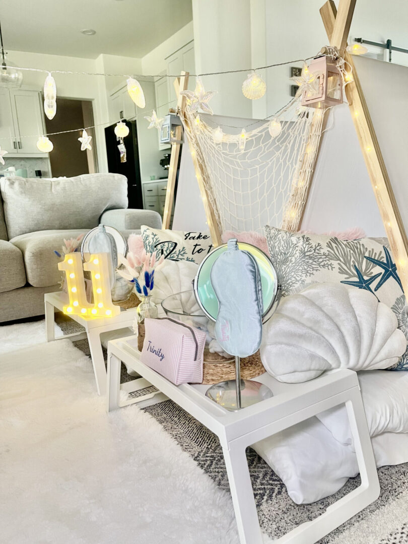 Cozy indoor tent with decorative pillows and lights.