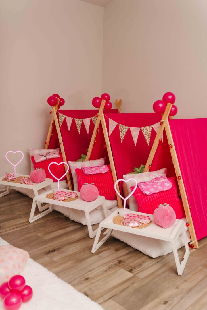 Pink indoor tents with heart decorations.