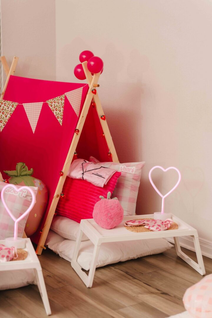 Pink-themed indoor tent with heart decorations.