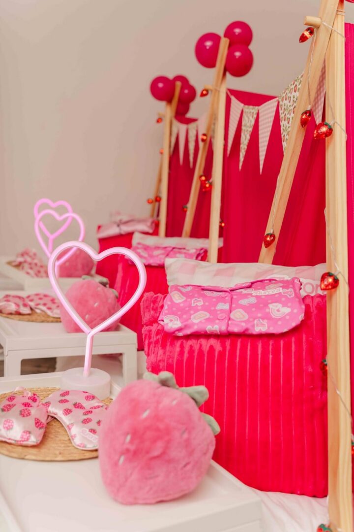 Pink-themed sleepover tents with heart decorations.