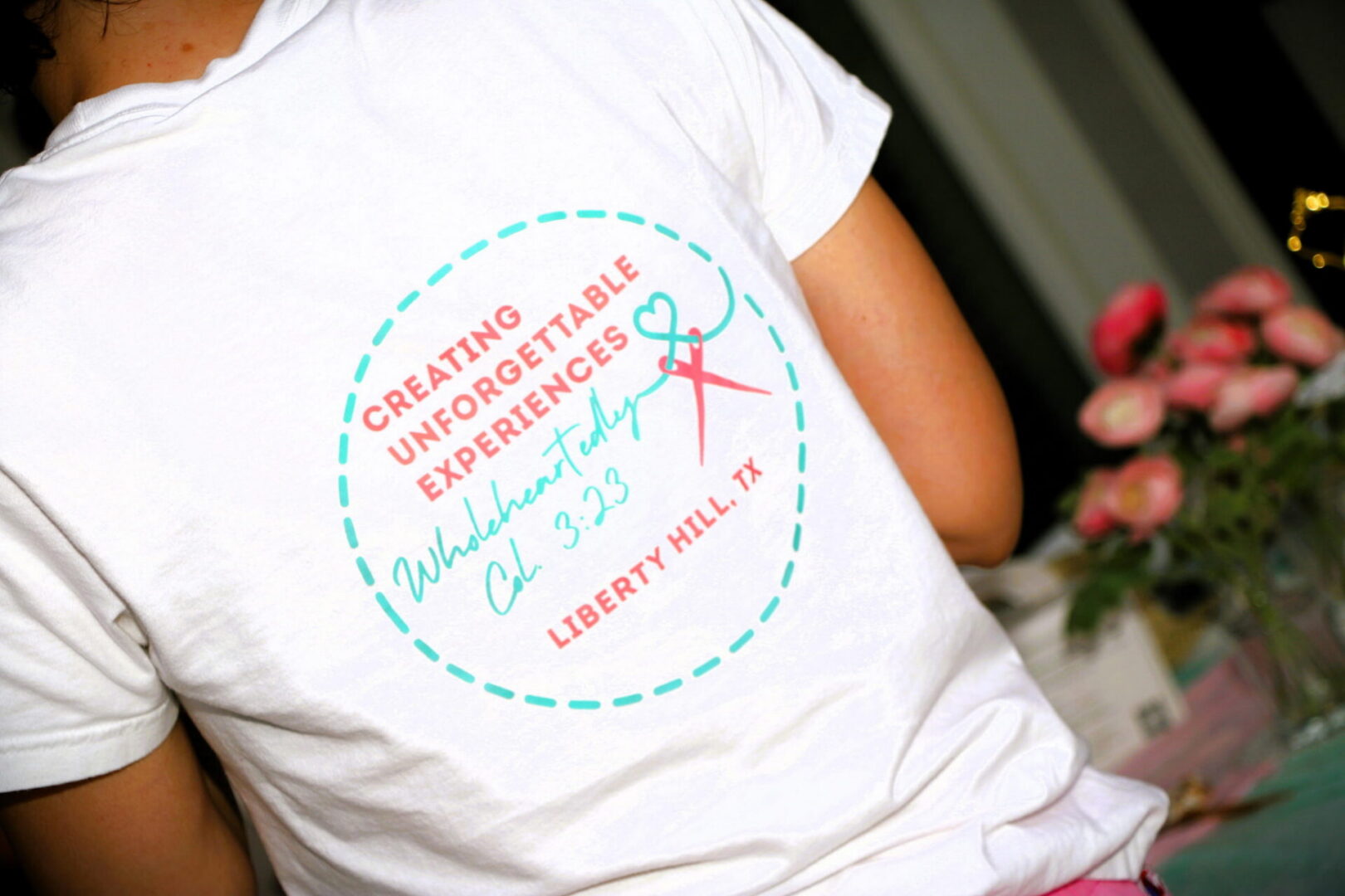 Person wearing event-themed white t-shirt.