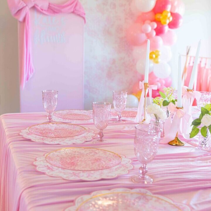 Table set for a baby shower with pink and white decorations